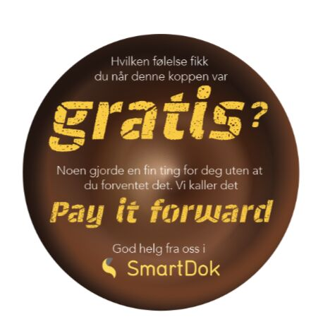Rund klistrelapp på en kaffekopp med teksten gratis – Pay it forward, God helg fra oss i SmartDok