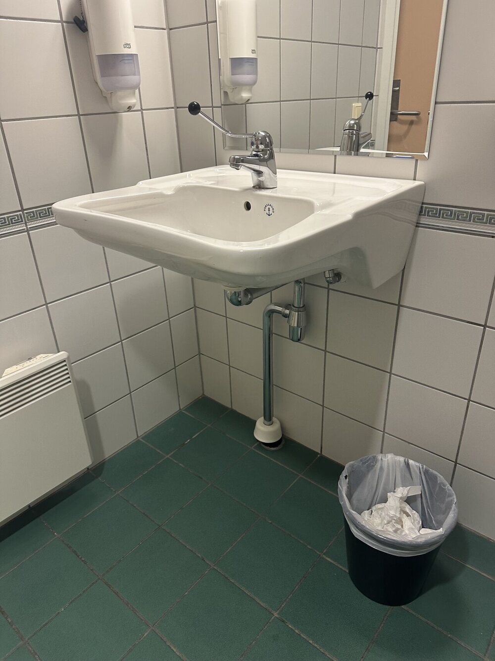 Det samme toalettrommet, nå ryddet med tørkepapiret samlet i søppelbøtta og vasken tørket over